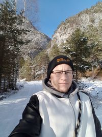 Portrait of young man standing on snow field