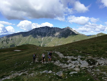 Hikers on mountain against sky at lombardy