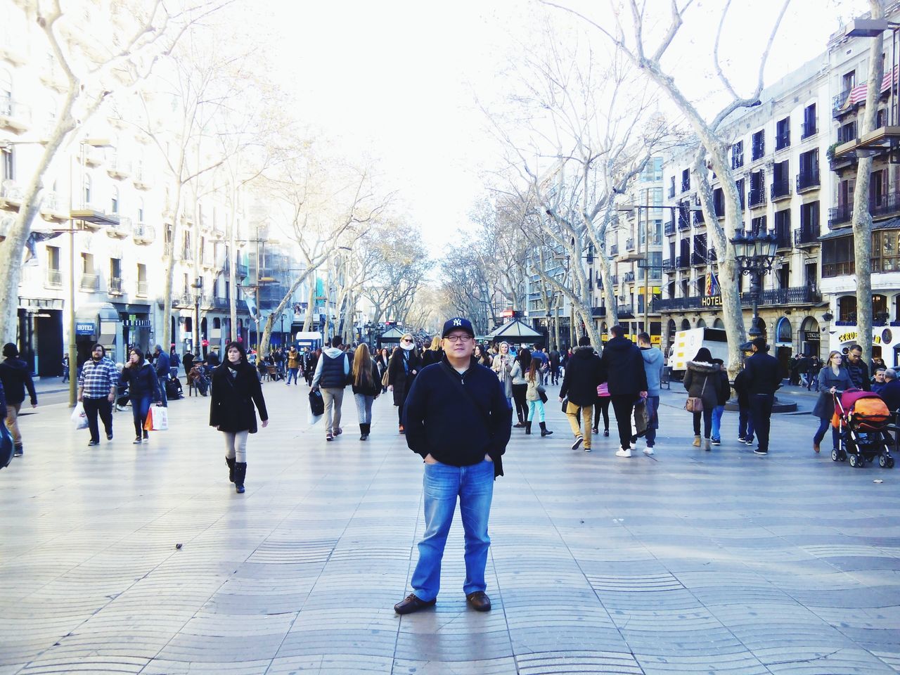 large group of people, building exterior, street, person, lifestyles, city, walking, city life, architecture, men, built structure, leisure activity, city street, tree, umbrella, mixed age range, crowd, full length, sidewalk