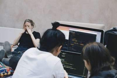 Male and female computer programmers using computer at office