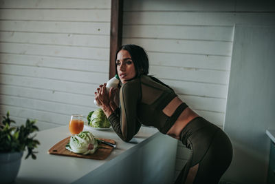 Woman drinking milk in kitchen at home