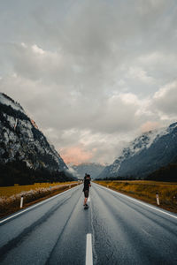 Rear view of man on road against sky