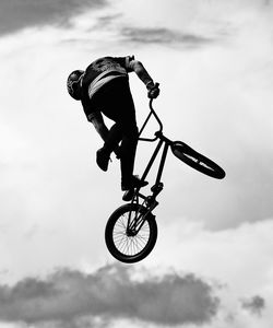 Low angle view of man jumping on bicycle