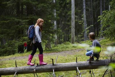 Boy and girl on fallen tree