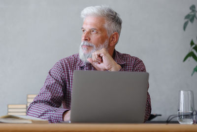Contemplative businessman with laptop in office