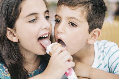 Close-up of siblings licking ice cream