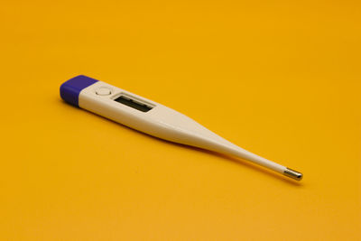 High angle view of pen on yellow background