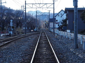 Railroad tracks in city against sky