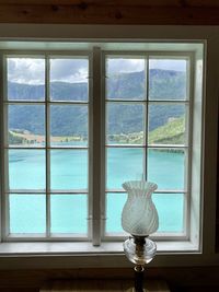 Close-up of glass window against sea