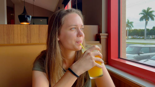 Young woman drinking glass at home