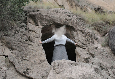 Rear view of woman standing on rock