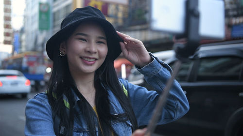 Portrait of a smiling young woman in city