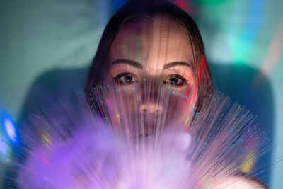 Close-up portrait of young woman with fiber optic