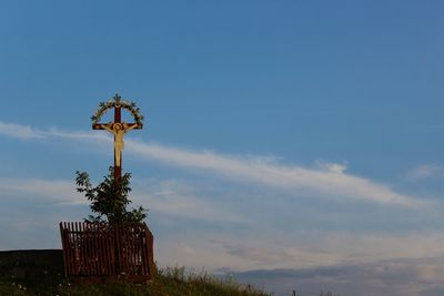 Crucifix on mountain against sky