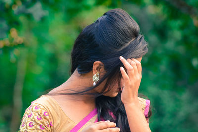 Close-up of young woman with hand in hair