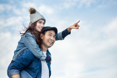 Portrait of smiling young woman against sky