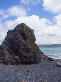 Rocks by sea against sky