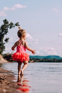 Full length of girl in sea against sky