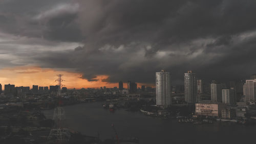 Panoramic view of city buildings against cloudy sky