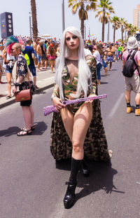 Full length portrait of confident woman wearing costume walking on road during parade