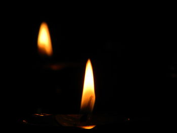 Close-up of lit candle in dark room