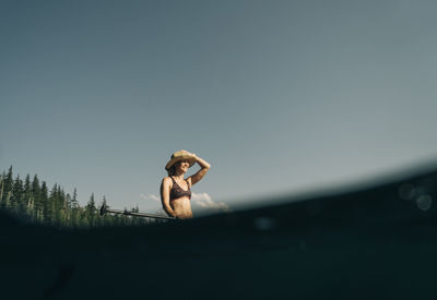 A young woman smiles while standup paddle boarding in oregon.