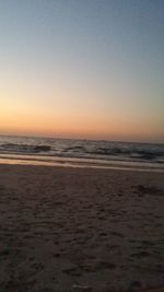 Scenic view of beach against clear sky during sunset