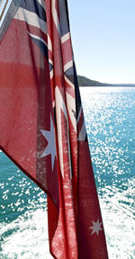 Close-up of flag against blue sea