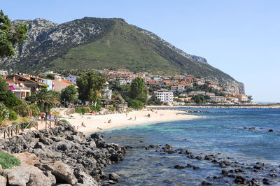 Scenic view of sea and mountains against clear sky