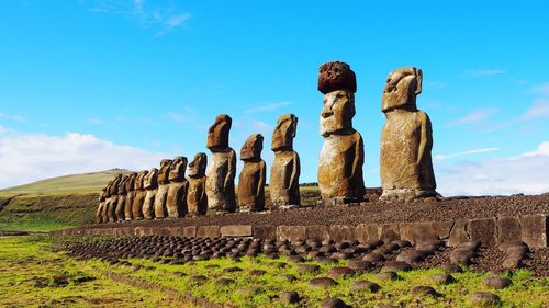 Statues on land against sky during sunny day