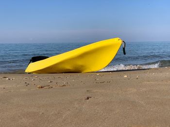 Yellow umbrella on beach against sky