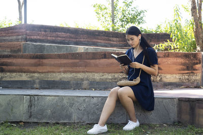 Full length of young woman using mobile phone