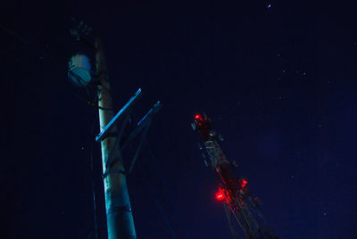 Low angle view of illuminated lights against sky at night