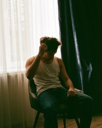 Young man sitting on chair at home