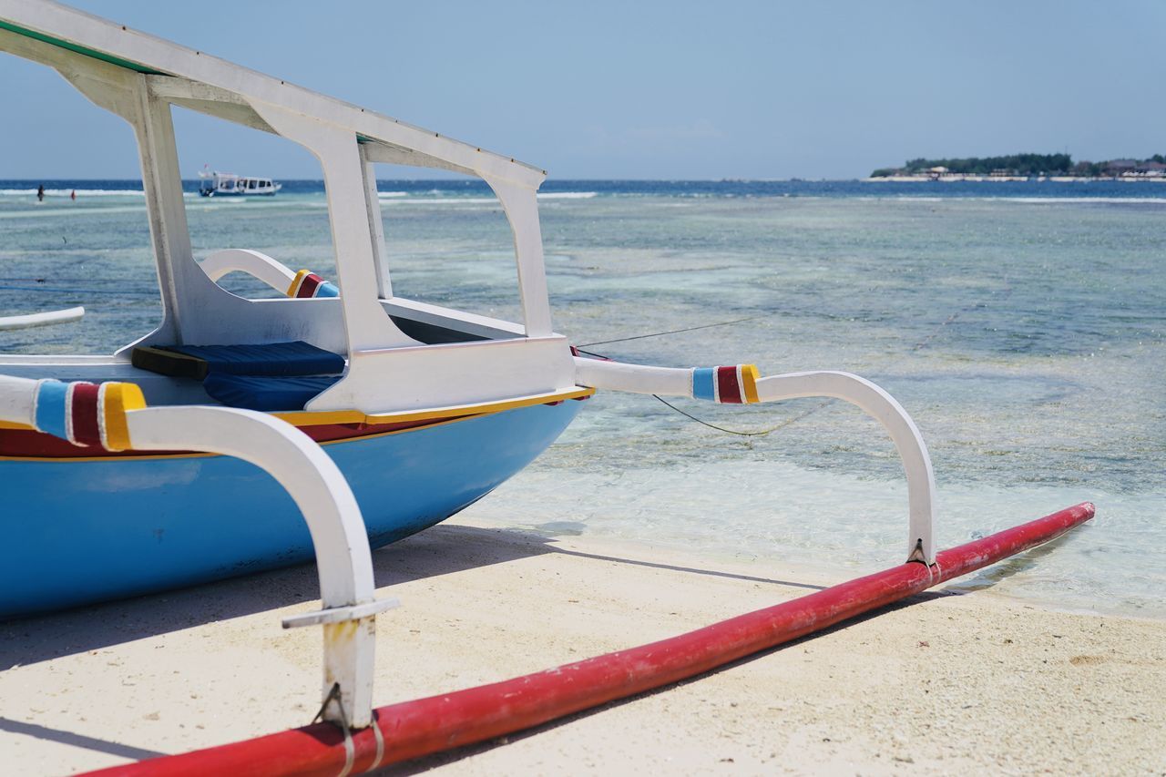 LOUNGE CHAIRS ON BEACH AGAINST SKY