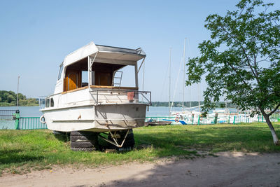 Old sailing yacht on land. old white motor yacht beached at a dock for painting and repair