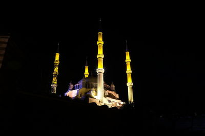 Low angle view of illuminated building against sky at night