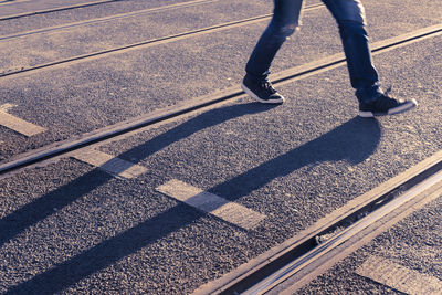Low section of people walking on railroad tracks