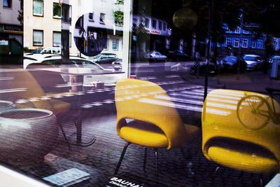 Close-up of yellow car on city street