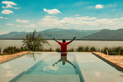 A man standing on a infinity swimming pool at lake jipe in tsavo west national park in kenya