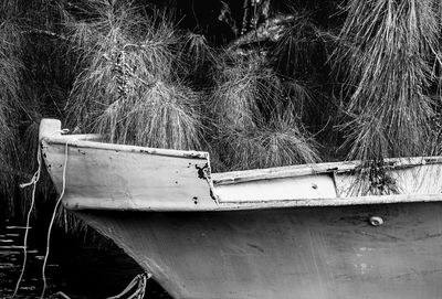 Close-up of abandoned boat moored on field