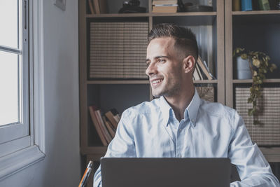 Smiling man looking away sitting at office