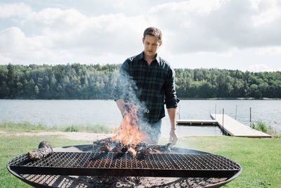 Man making a bbq outside at the beach in sweden