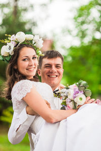 Portrait of bride and bridegroom holding bouquet