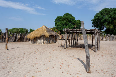 Wooden hut on beach against sky