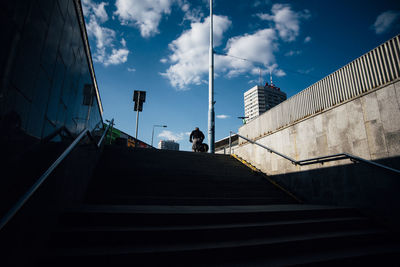 Low angle view of staircase amidst buildings in city against sky