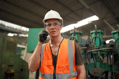 Portrait of young man standing in factory