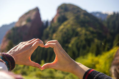 Close-up of people making heart shape