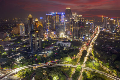 High angle view of illuminated street amidst buildings at night