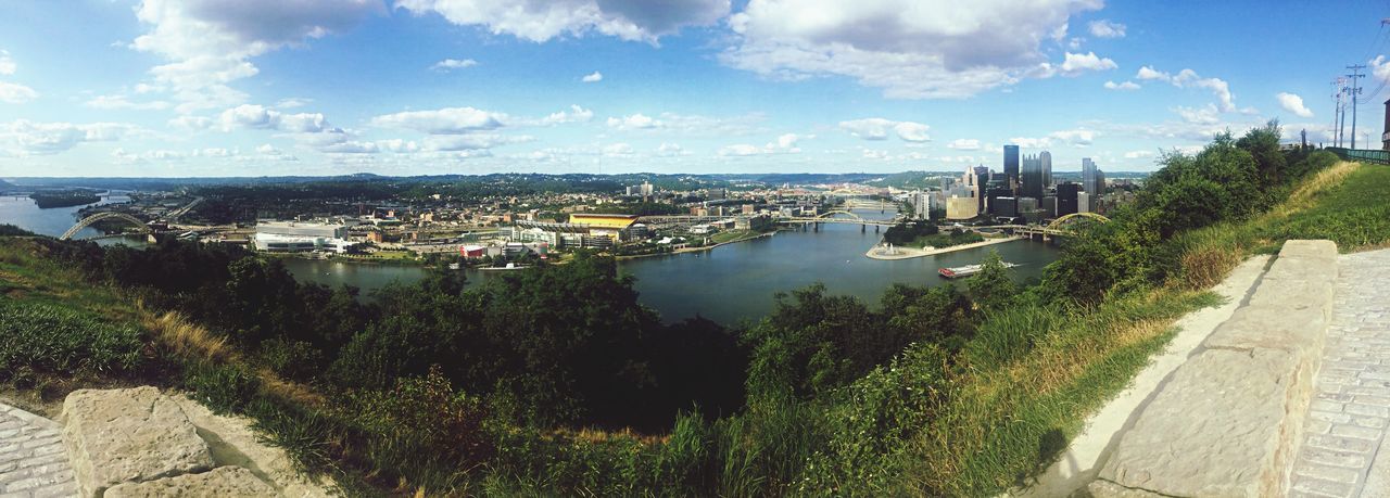 sky, water, building exterior, built structure, architecture, sea, cloud - sky, tree, high angle view, cloud, city, panoramic, plant, growth, sunlight, day, nature, river, grass, outdoors